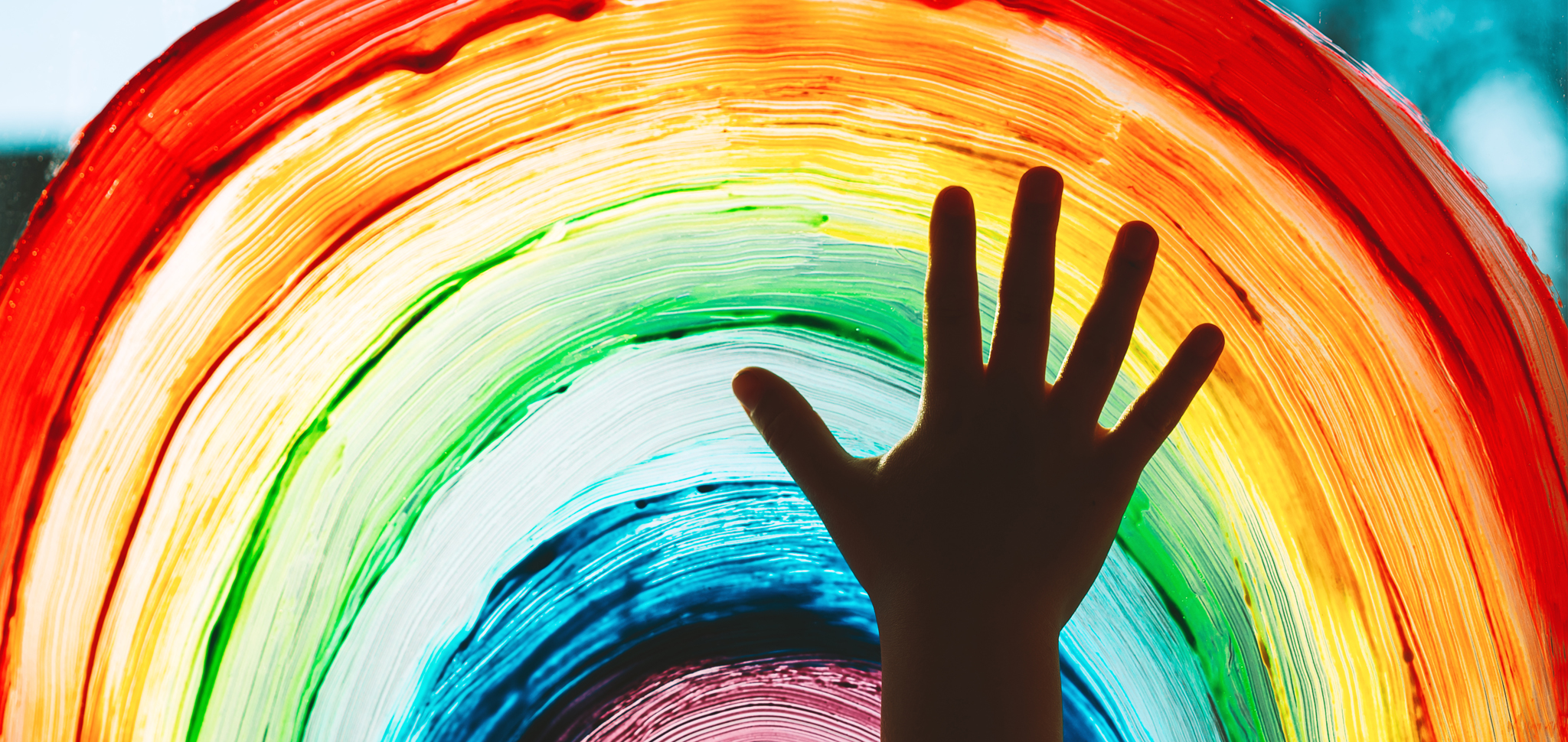 painting of hand in front of rainbow