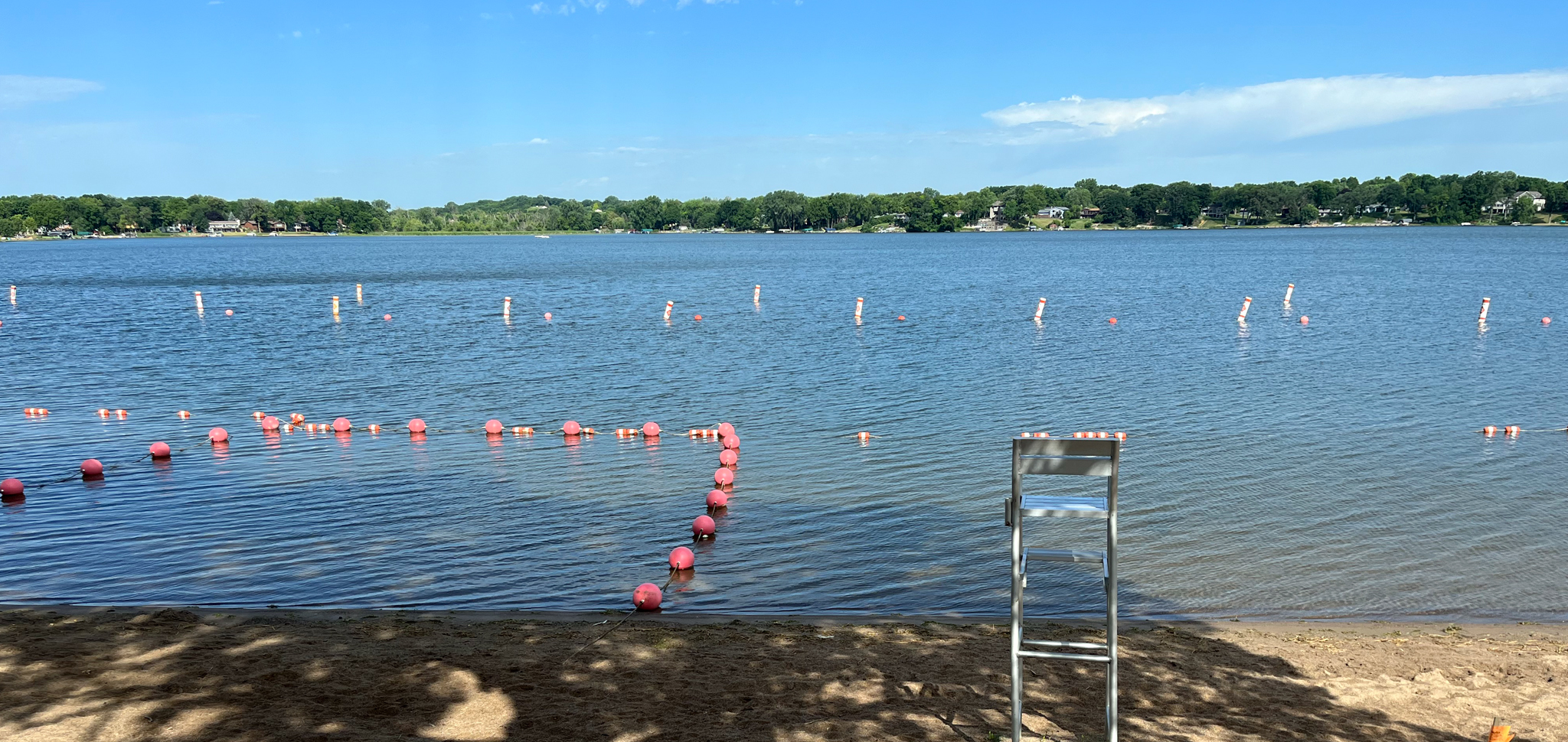 Lake with a beach and empty lifeguard chair