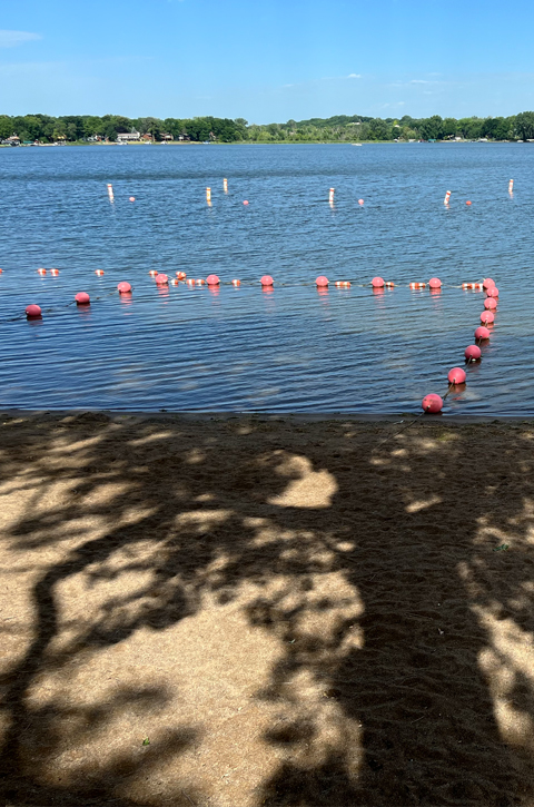 Lake with a beach and empty lifeguard stand 
