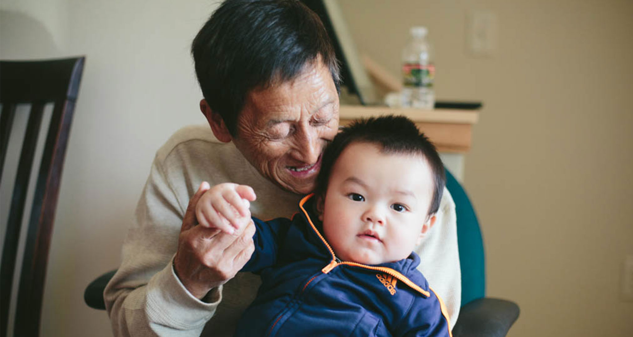 Older man holding grandson
