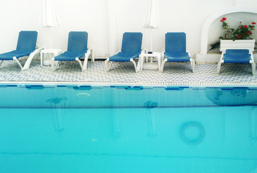 Swimming pool with deck chairs